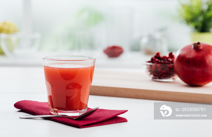 Fresh red pomegranate juice in a glass, vitamins and healthy diet concept