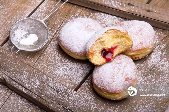 Traditional Polish donuts on wooden background.  Tasty doughnuts with jam.