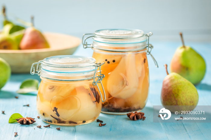 Natural and juicy pickled pears on blue table