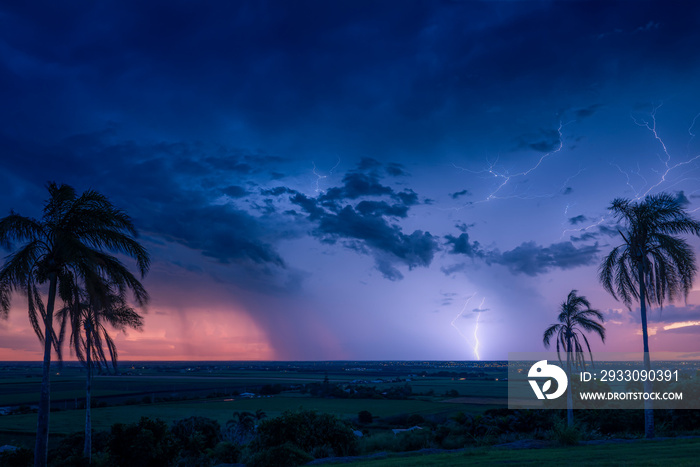 A thunder storm crosses the horizon behind the city of Bundaberg on sunset.