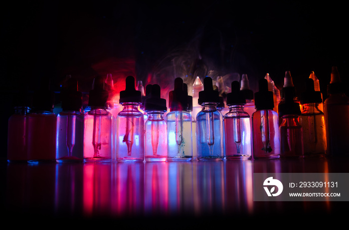 Vape concept. Smoke clouds and vape liquid bottles on dark background. Light effects. Useful as background or vape advertisement or vape background. Selective focus