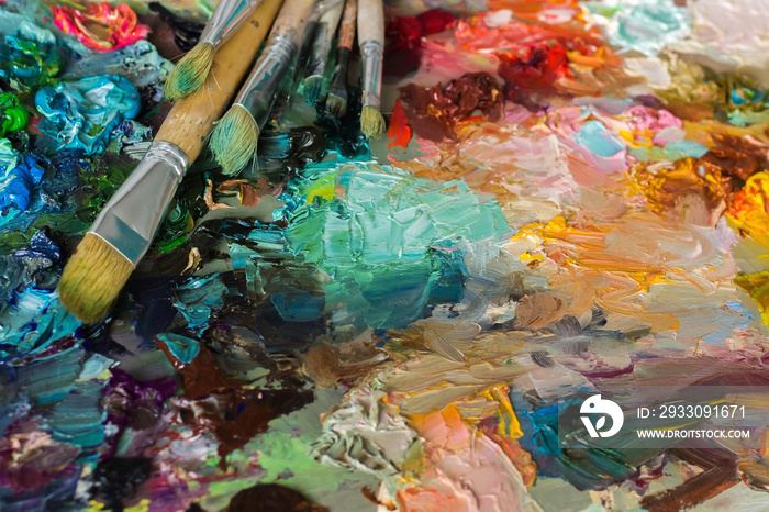 artist’s palette with oil paints and brushes used for painting a