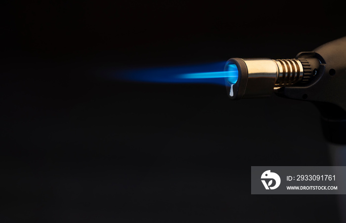 Blue flame from a gas torch burner on black background