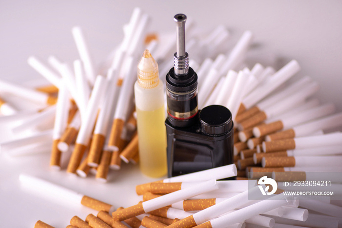 Pile of cigarettes and modern electronic cigarette. vape vs cigarettes