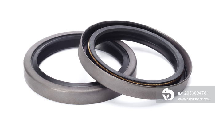 Two rubber reinforced oil seals for shafts and for car motor engines, isolated on white background. Cuffs for prevent liquid leak. Car parts.