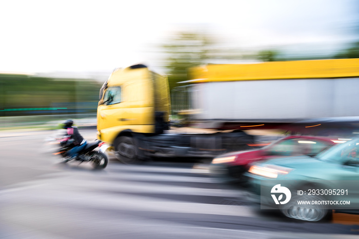 Dangerous city traffic situation with a motorcyclist and a truck