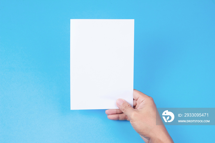 Blank brochure with blank in hand on blue background. Mockup for design