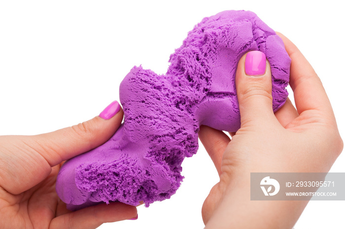 Close-up of a photo in the hands of kinetic sand on a white background