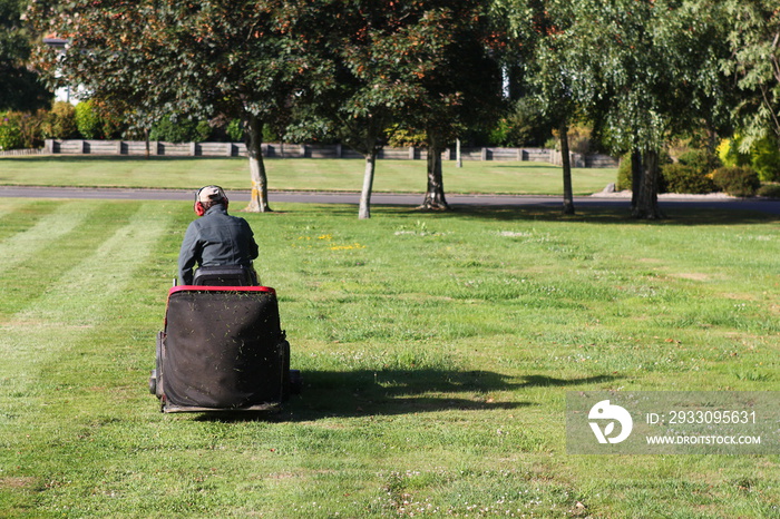 man operating a ride-on lawnmower in a park