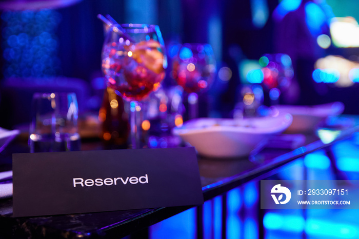 Reserved table in night club against the background of multi-colored spotlights