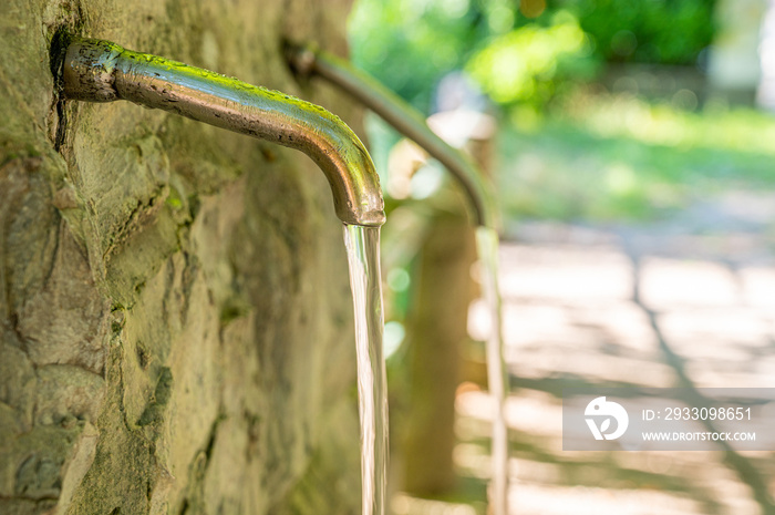 Tap from which drops of water flow. Drought, shortage, rationing and proper use of water.