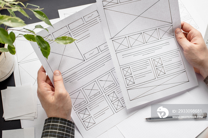 UX website designer drawing wireframe sketch of prototype, framework, layout future project. Creative user experience concept website template. Designer workspace