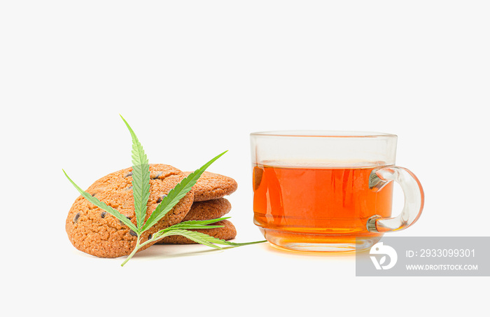 Cannabis chocolate chip cookies with a marijuana leaf and a glass of cannabis tea on a white background