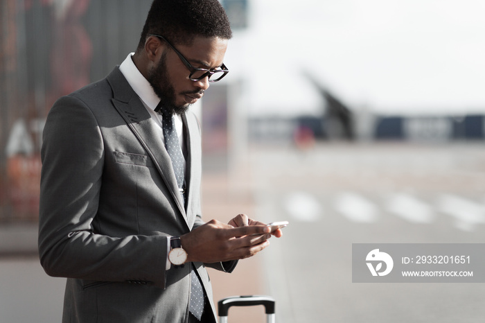 Ordering Taxi. Afro Businessman Using Mobile Phone App