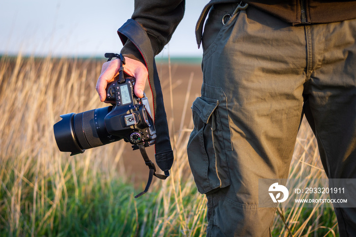 Photographer holding camera outdoors