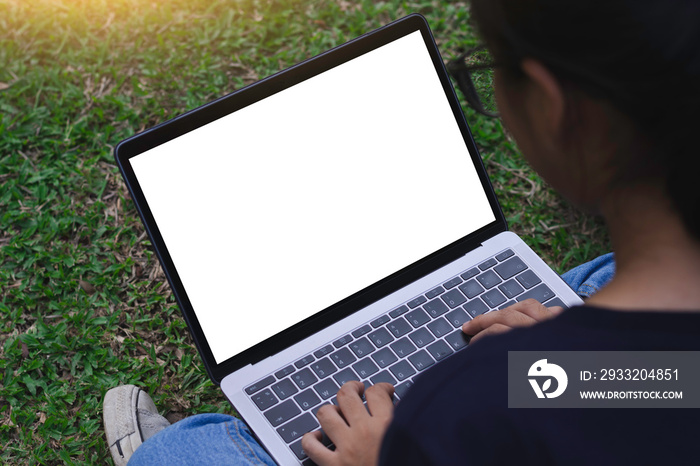 Casual business woman typing on laptop computer keyboard with green nature background. Clipping path