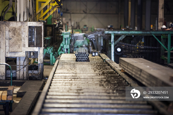 Bundle of steel pipes moving on conveyor belt