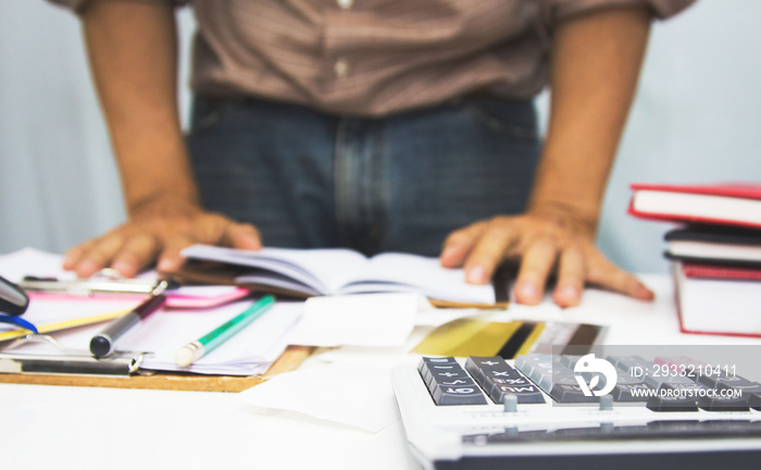 businessman using calculator and holding pen on tax paper in office.Accounting.concept.