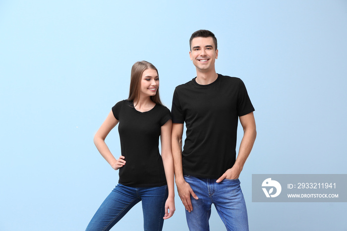 年轻的女人和男人穿着彩色背景的黑色t恤。设计模型