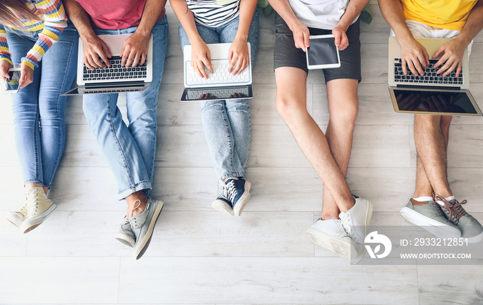 Students with modern devices studying online indoors