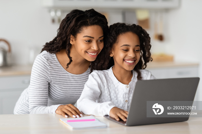 Smiling african american mom helping her studying kid, copy space