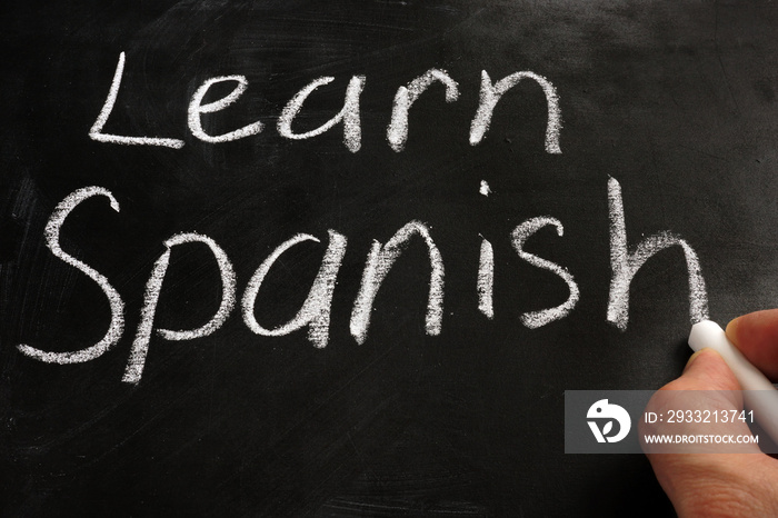 Learn Spanish handwritten sign on a blackboard.