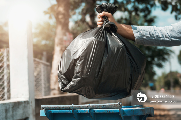 woman hand holding garbage black bag put in to trash