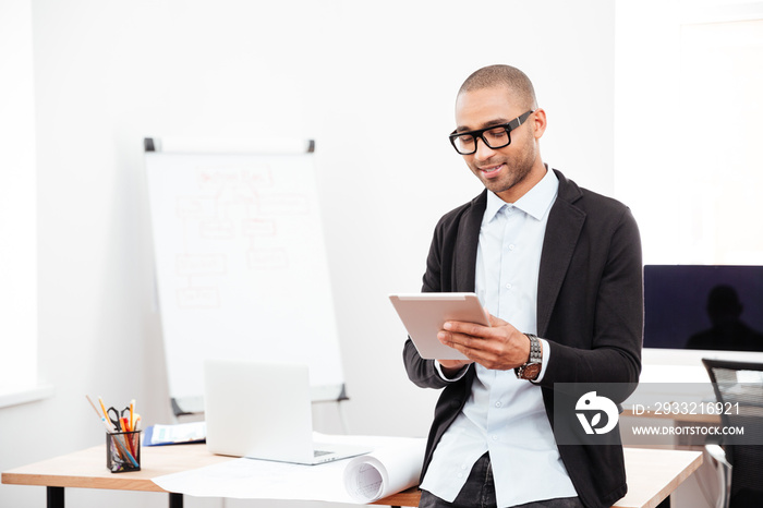 Happy young businessman using pc tablet in office