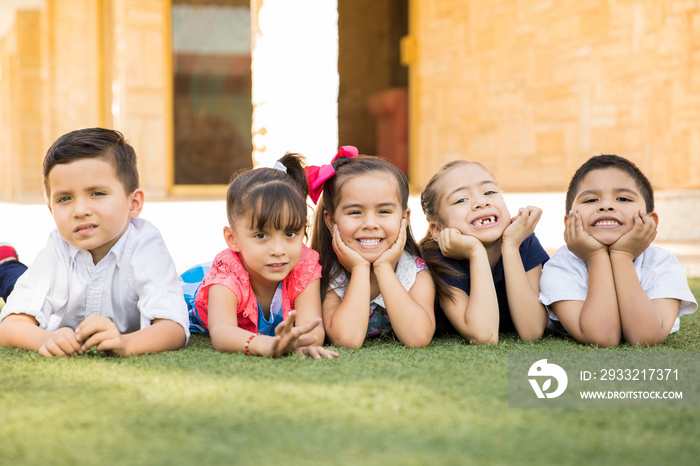 Preschool friends lying on the grass