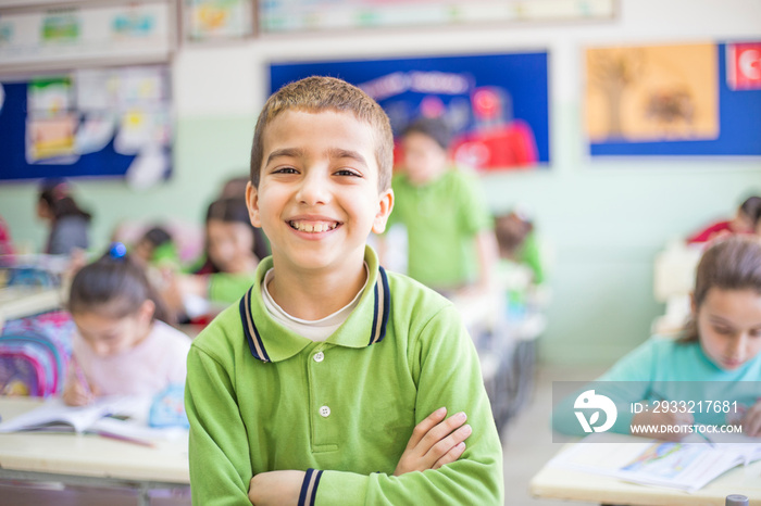 Portrait of ten years old male student. smiling standing in classroom