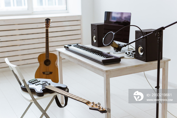 Microphone, computer and musical equipment guitars and piano background. Home recording studio conce