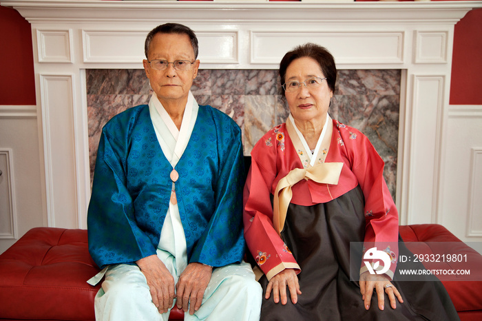 Portraying of senior couple wearing traditional clothing sitting on couch