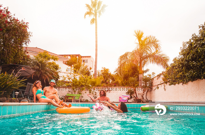 一群快乐的朋友在游泳池里放松——年轻人在空中享受漂浮的乐趣lilo duri
