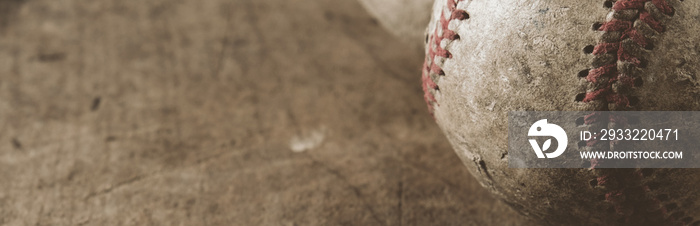 Old used baseball texture close up with wood background.