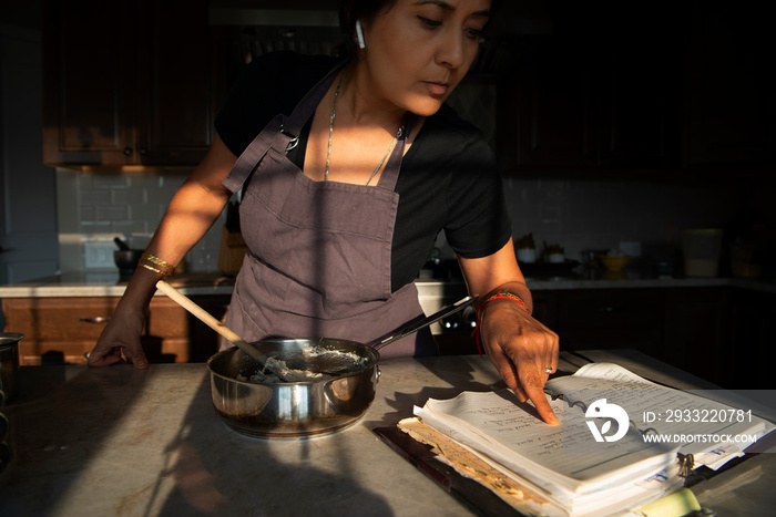 女人在看旧食谱和烹饪