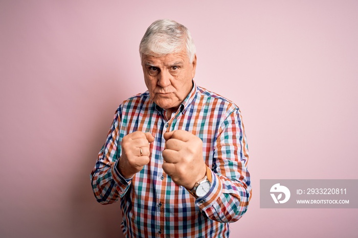 Senior handsome hoary man wearing casual colorful shirt over isolated pink background Ready to fight