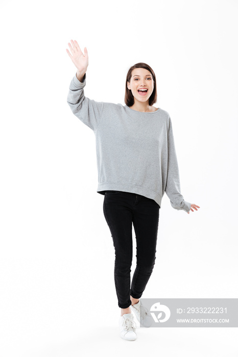 Full length portrait of a girl waving hand to camera