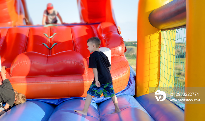 Full length of boy playing on bouncy castle