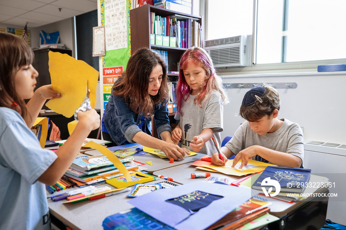 Teacher helping children in a classroom