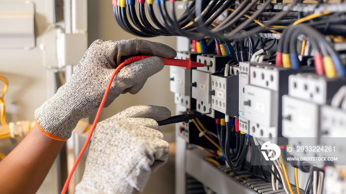 Electrician engineer uses a multimeter to test the electrical installation and power line current in