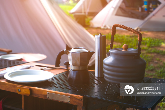 露营桌上的复古户外黑水壶、咖啡研磨机和户外厨房设备，带mor