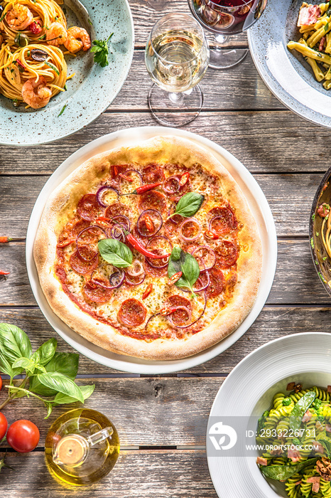 视野之巅，一整桌意大利餐摆在盘子和平底锅上。披萨意大利面意大利饭汤和鱼蔬菜