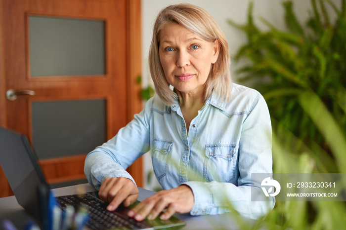 Mature woman looking at laptop at home