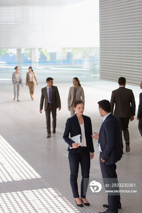 Corporate business people talking in modern lobby