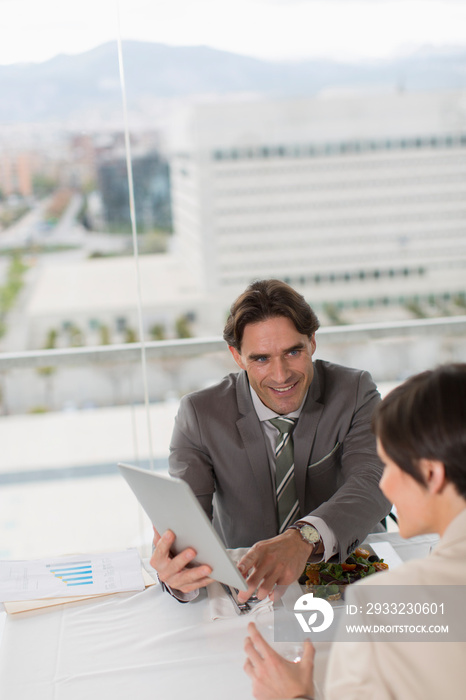 Business people eating lunch and using digital tablet in office