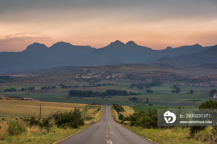 A road leading towards the Drakensberg mountains at sunrise near Clarens, South Africa
