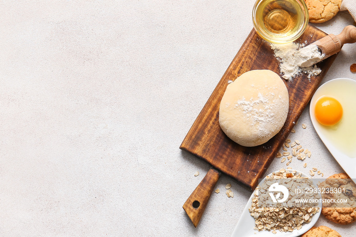 Wooden board with dough for preparing homemade cookies and ingredients on light background