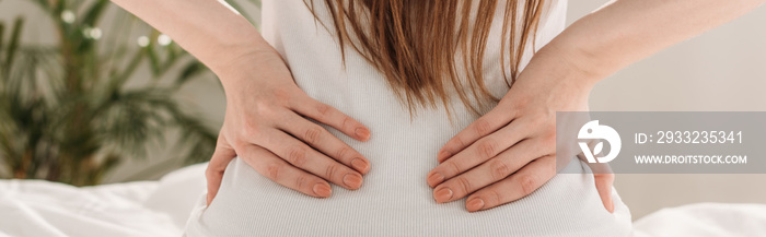 cropped view of girl touching loin while suffering from pain, panoramic shot