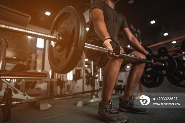 A side view of a young bodybuilder exercising in the gym, ready to lift weights, lift weights, work 