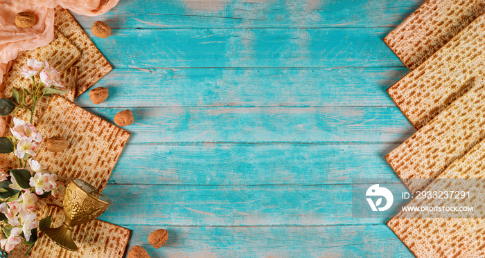 Jewish matzah bread with wine cup and flowers on wooden background. Passover holiday concept